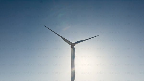 Rotating wind turbine against blue sky, clean energy generation