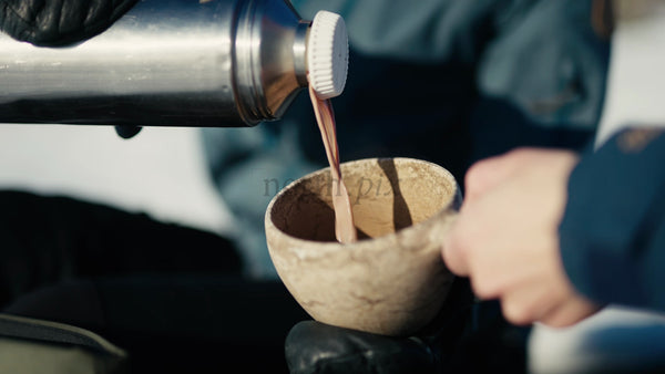 Pouring a Hot Drink into a Kuksa Mug in the Winter Luleå Archipelago, Sweden