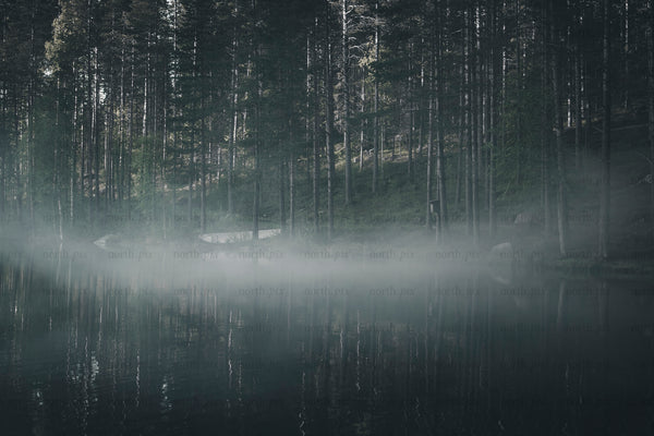 Boat on foggy lake at dawn