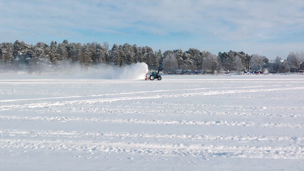 Tractor clearing snow on frozen lake in Luleå winter landscape