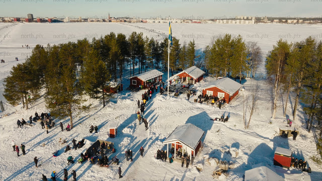Winter fun in Luleå: Aerial view of ice skating, snowmobiling, and sledding on a frozen lake