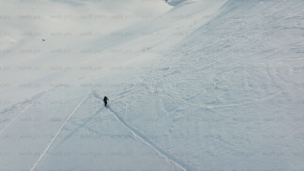 Skier making fresh tracks on a sunny snowy slope at Riksgränsen ski resort