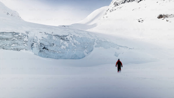 Man walking towards glacier in snowy Riksgränsen