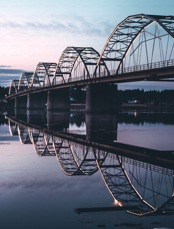 Arched steel bridge with reflection at dusk