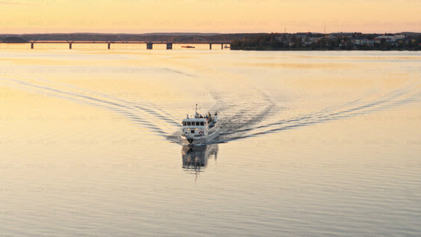 Luleå: Passenger ferry sails at sunset - golden hour aerial drone footage