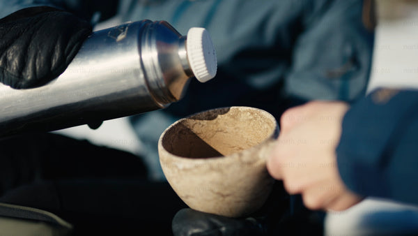 Pouring hot chocolate into a kuksa in the snowy Luleå archipelago winter