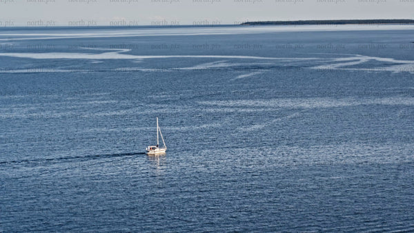 Summer evening sailboat in Luleå: Calm blue waters and island views