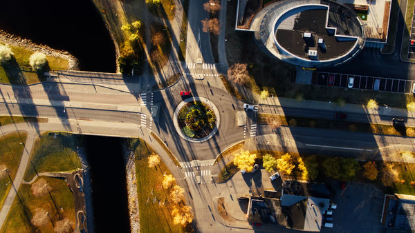 Aerial top-down view of Piteå city roundabout with moving cars in autumn sunlight