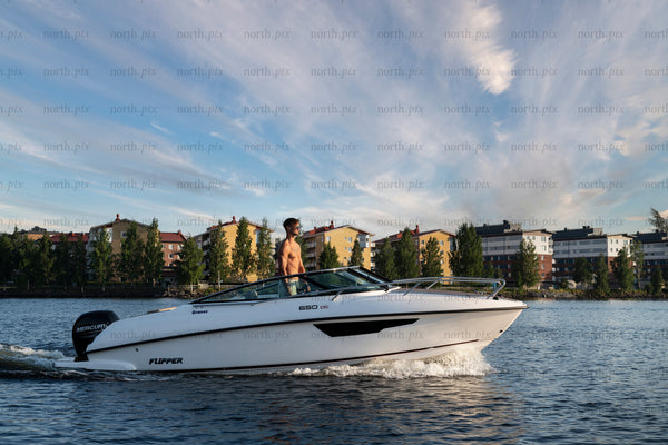 Man driving motorboat on river at sunset