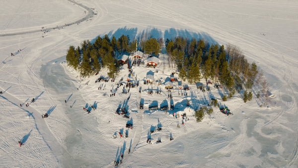 Winter wonderland in Luleå: Aerial view of snowy island, frozen lake, and ice skating