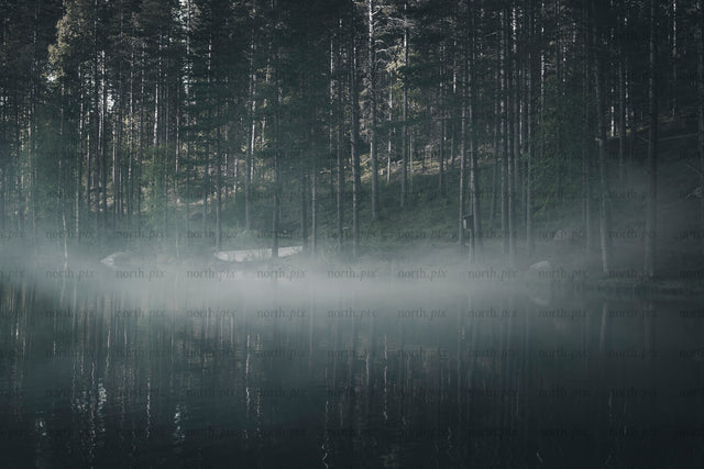 Boat on foggy lake at dawn