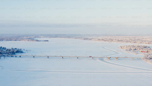 Winter Sunrise Over Frozen River and Bridge in Luleå, Sweden