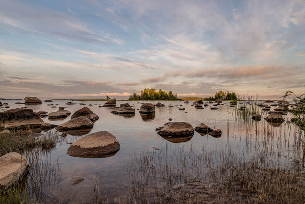 Rocks and small island in shallow lake at sunset