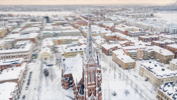 Aerial timelapse of Luleå cathedral and cityscape in snowy winter at sunset