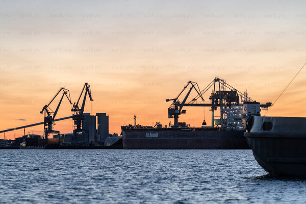 Cargo ship loading at industrial port of Luleå during sunset