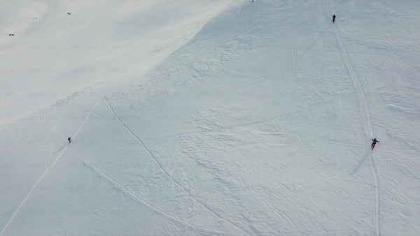 Skiers and snowboarders descend snowy mountain at riksgransen, Sweden