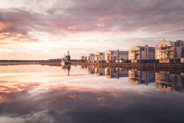Waterfront apartment buildings "tuttifrutti" reflected in calm sunset water