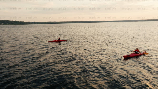 Kayaking at sunset: Two people explore a calm lake in Luleå
