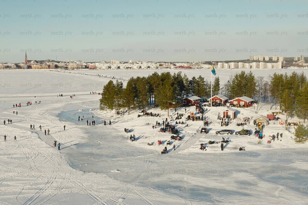 Luleå city center winter scene with snow, trees, and people enjoying the park
