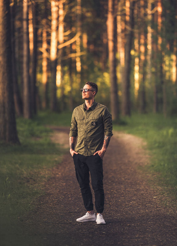 Man standing on forest path at golden hour