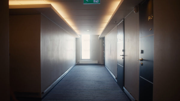 Businesswoman walking down hotel hallway with luggage in Luleå