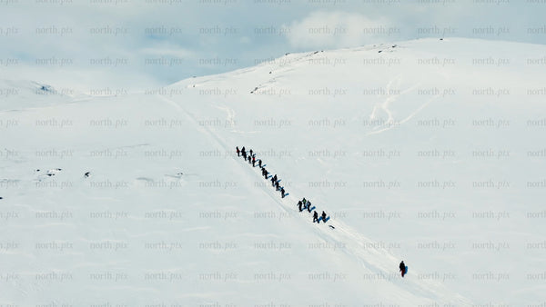 Group hiking up snowy mountain in Riksgränsen