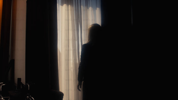 Businesswoman opens curtains in hotel room, city view, new opportunities