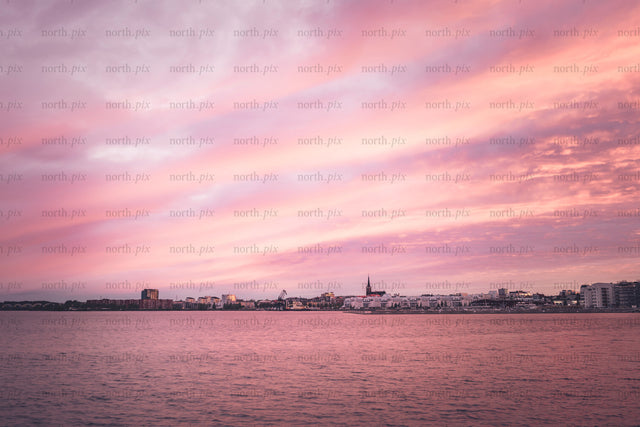 Harbor skyline with church spire at sunset