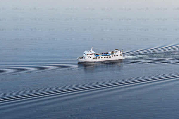 White ferry cruising through calm blue waters near Luleå city center on a clear day