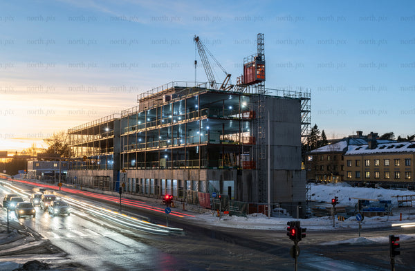 Construction site with crane and traffic at dusk