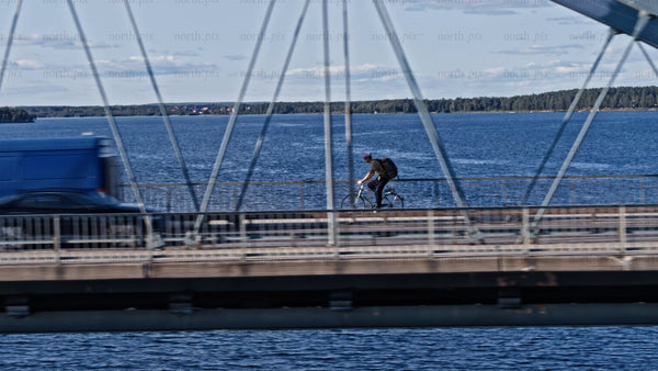 Luleå cityscape: Cars and bikes crossing Bergnäsbron bridge on a sunny summer day