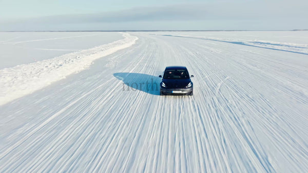 Tesla/Car Driving on Snowy Ice Road in Winter, Luleå, Sweden - Drone Shot