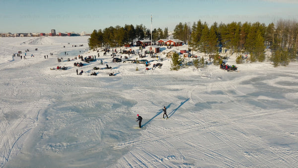 Winter wonderland in Luleå: Aerial view of skiing, snowmobiling, and lakeside cabin