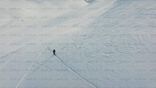 Skier making fresh tracks on a sunny snowy slope at Riksgränsen ski resort