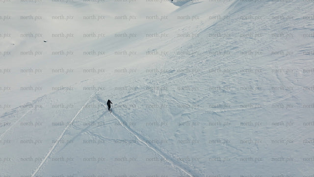Skier making fresh tracks on a sunny snowy slope at Riksgränsen ski resort