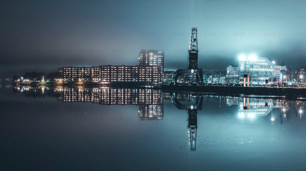 Industrial crane and waterfront buildings at night panorama