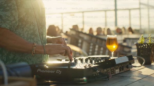 DJ playing music at sunset rooftop party in Luleå
