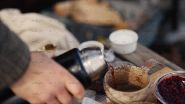 Winter picnic in the Luleå archipelago: Pouring a hot drink into a kuksa mug