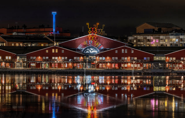 Night view of red waterfront theater with reflections