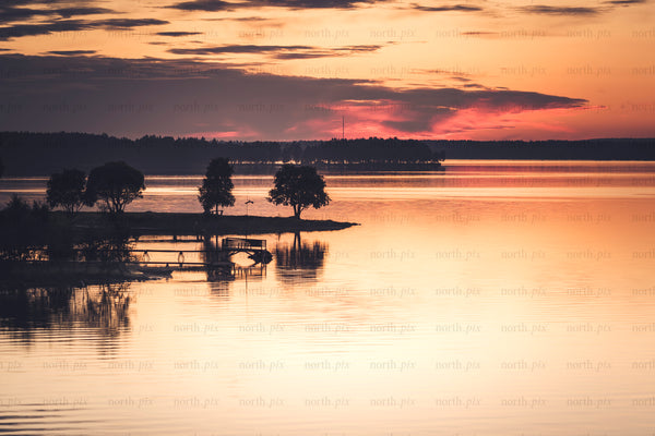 Sunset over lake with pier and trees, Bergnäset