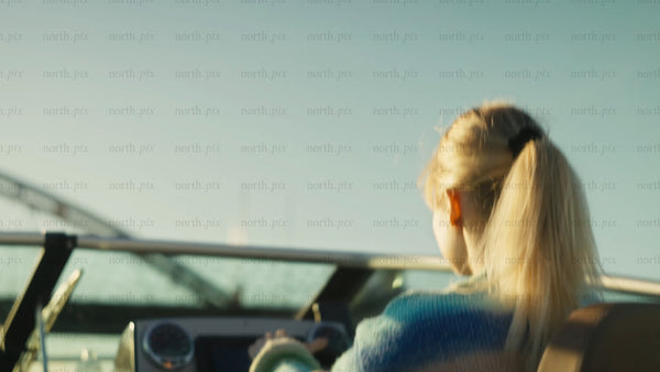 Young woman boating in the Luleå archipelago at sunset during summer