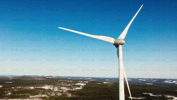 Close up of wind turbine in snowy Markbygden, winter, blue sky, aerial view