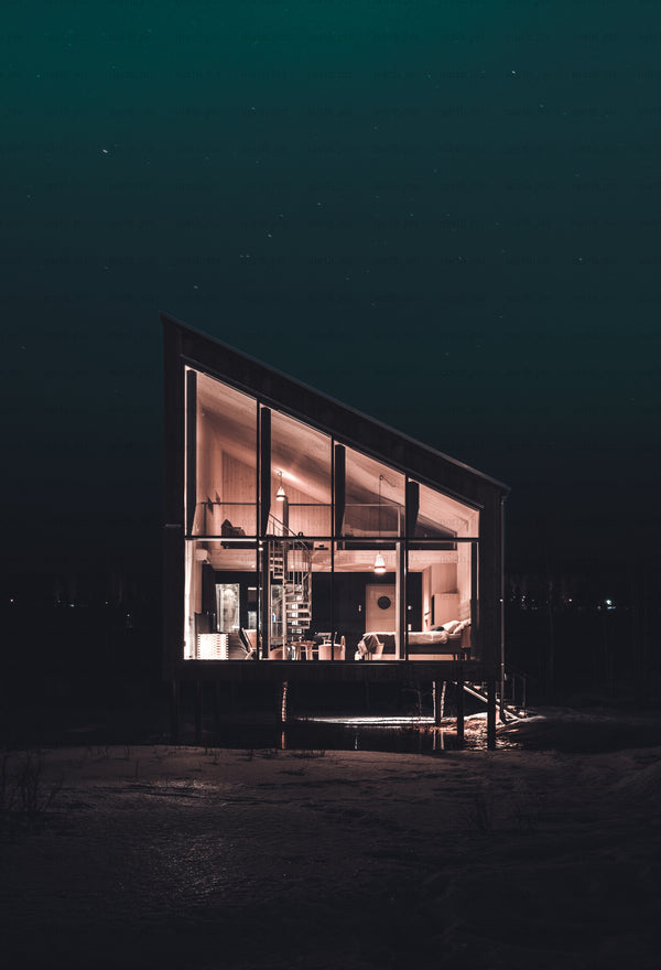 Modern glass cabin elevated on stilts at night