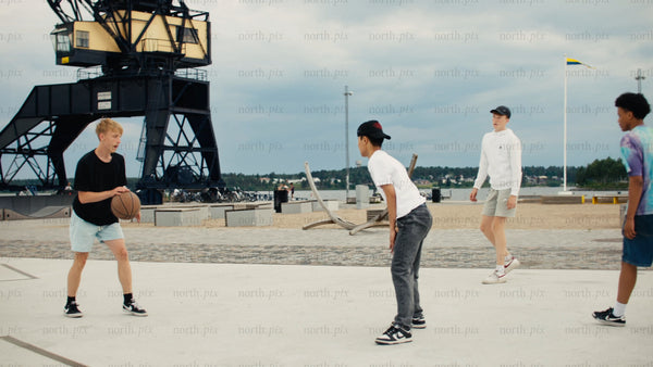 Urban basketball fun: Friends shoot hoops in Luleå on a summer day