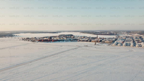 Aerial view of Luleå cityscape in winter at sunset on frozen lake