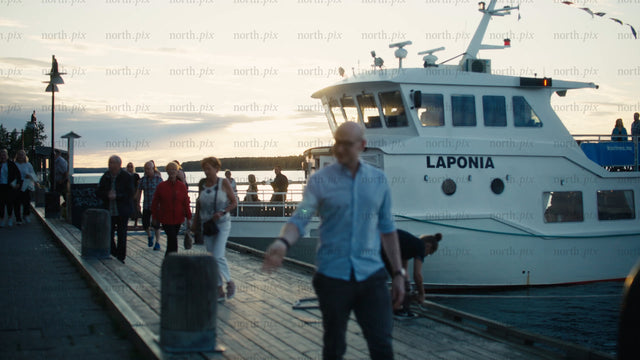 Passengers disembarking ferry at sunset on Luleå pier