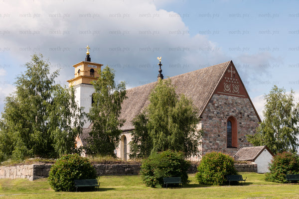 Stone church with bell tower and birch trees