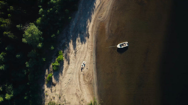 Summer day in Luleå archipelago: Aerial view of beach, boat, and people