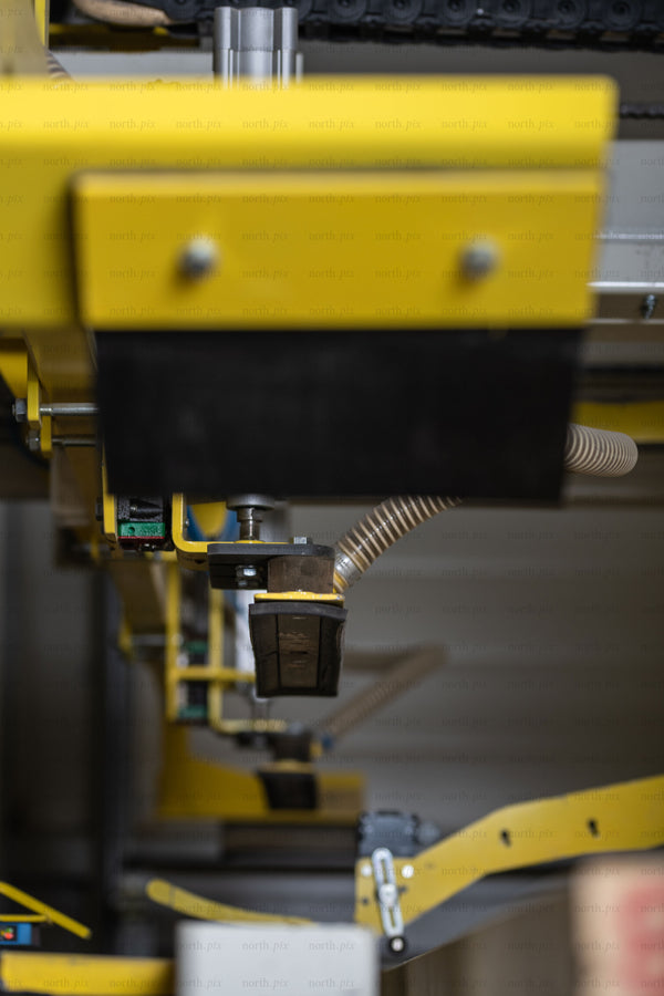 Close-up of yellow conveyor gripper in factory