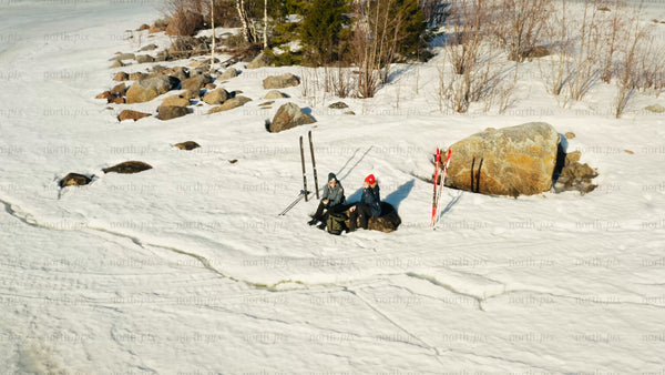 Winter skiing in Luleå: Aerial drone view of skiers resting on a frozen lake island